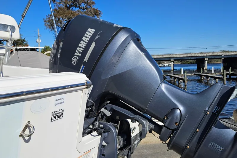 Slide: The Image of 2014 Sea Fox 199 Commander with Yamaha outboard motor, docked by a scenic waterfront. - 2