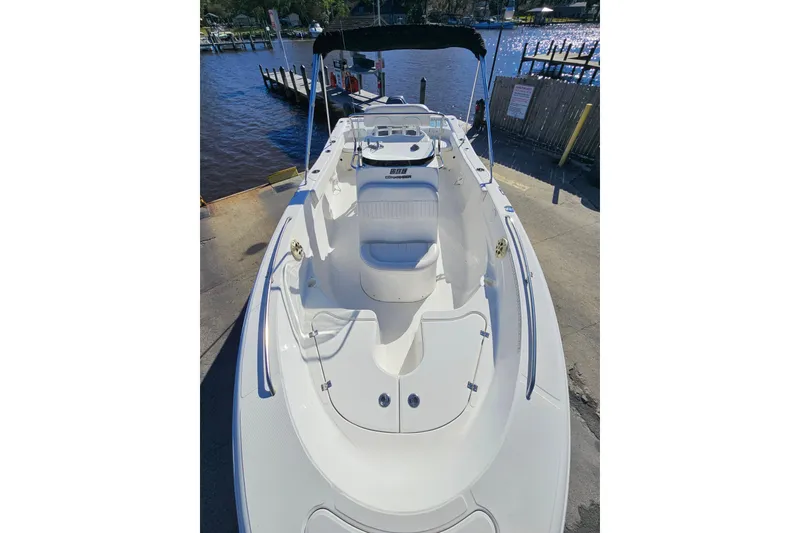 Slide: The Image of 2014 Sea Fox 199 Commander boat docked by the water, showcasing spacious deck and seating. - 5