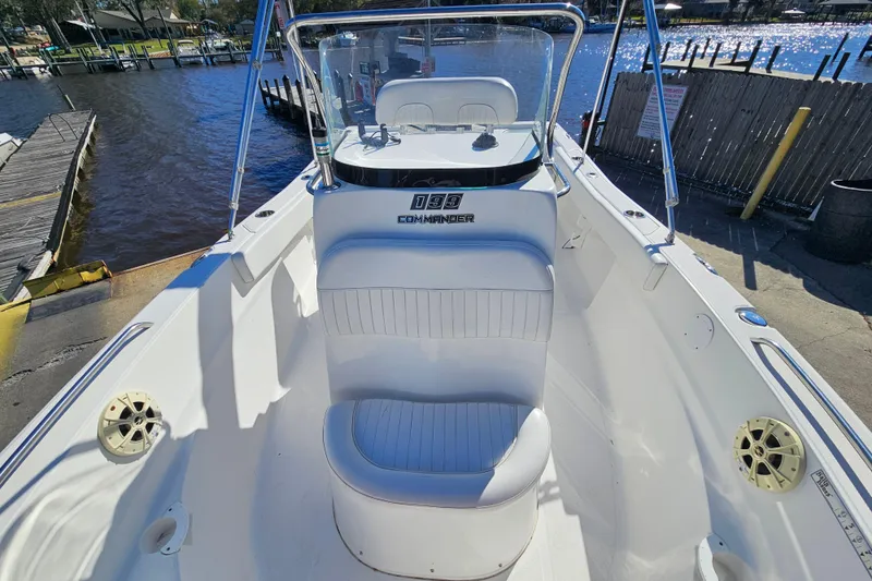 Slide: The Image of 2014 Sea Fox 199 Commander boat interior with seating and console, docked by the water. - 7