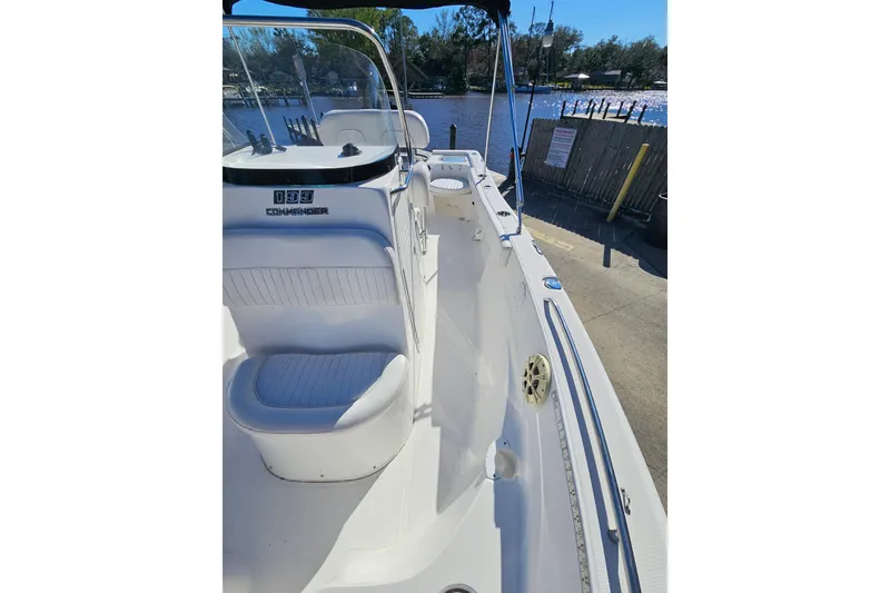 Slide: The Image of 2014 Sea Fox 199 Commander boat interior with seating and console, docked by the water. - 8