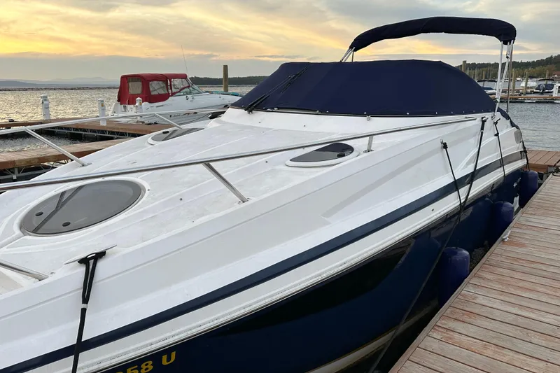 Slide: The Image of 2014 Regal 28 Express boat docked at sunset, featuring sleek design and covered deck. - 15