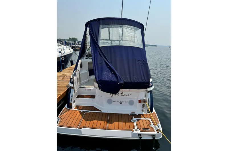 Slide: The Image of 2014 Regal 28 Express boat docked with blue canopy and wooden deck. - 3