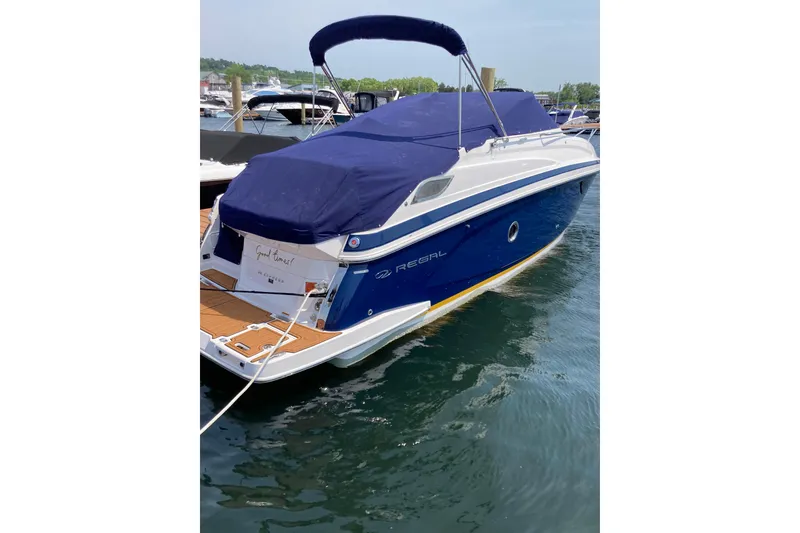 Slide: The Image of 2014 Regal 28 Express boat docked with blue cover and sleek design. - 7