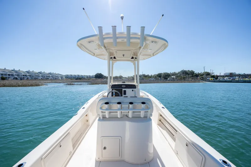 Slide: The Image of 2024 Grady-White 251 Coastal Explorer boat on calm water, clear sky background. - 16