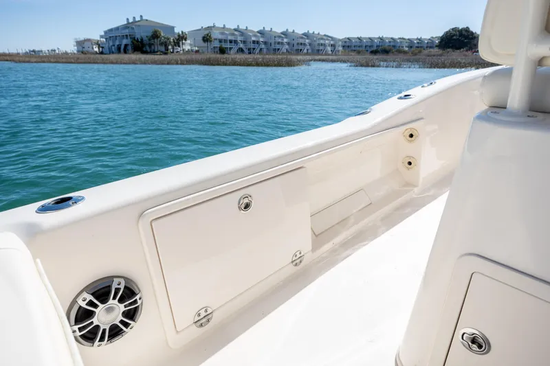 Slide: The Image of 2024 Grady-White 251 Coastal Explorer boat interior with water and buildings in the background. - 17