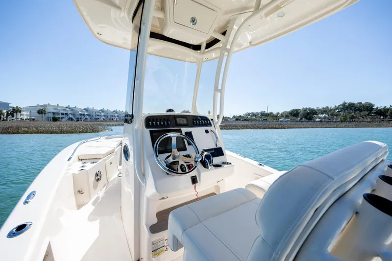 Slide: The Image of 2024 Grady-White 251 Coastal Explorer boat interior with steering console on calm water. - 20