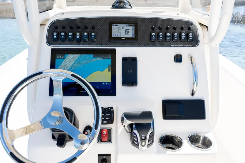 Slide: The Image of 2024 Grady-White 251 Coastal Explorer dashboard with steering wheel and navigation controls. - 23