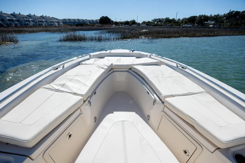 Slide: The Image of 2024 Grady-White 251 Coastal Explorer boat interior with cushioned seating, near shoreline. - 26