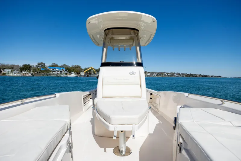 Slide: The Image of 2024 Grady-White 251 Coastal Explorer boat on calm water, clear blue sky. - 27