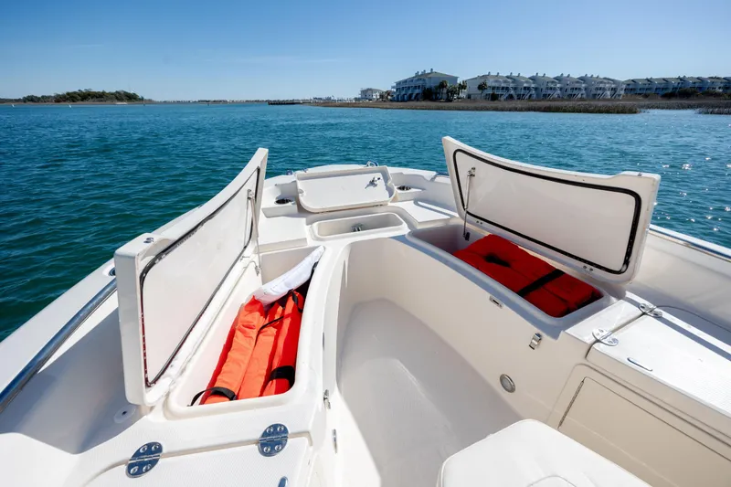 Slide: The Image of 2024 Grady-White 251 Coastal Explorer boat with open storage compartments on calm water. - 28