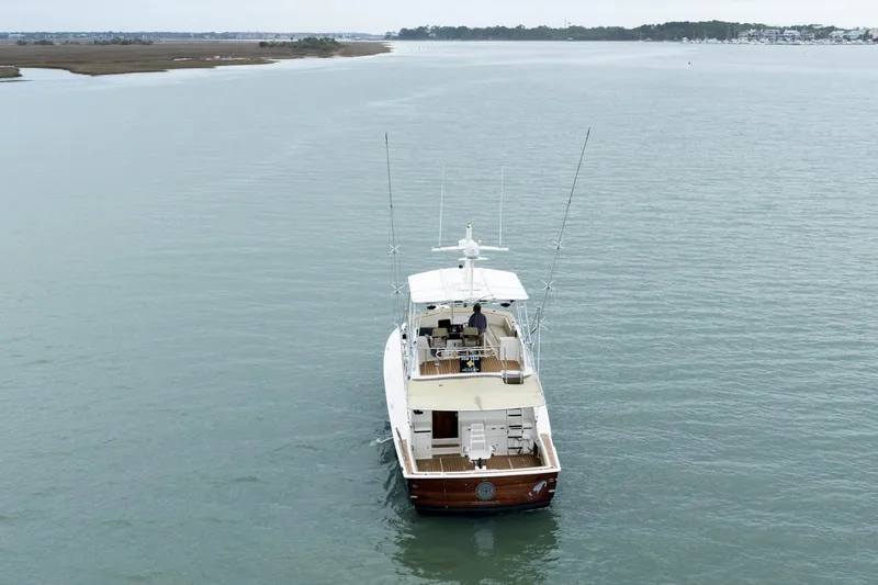 Slide: The Image of 1984 Hatteras 52 Convertible yacht cruising on calm waters. - 11