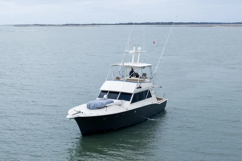 Slide: The Image of 1984 Hatteras 52 Convertible yacht cruising on calm waters. - 16