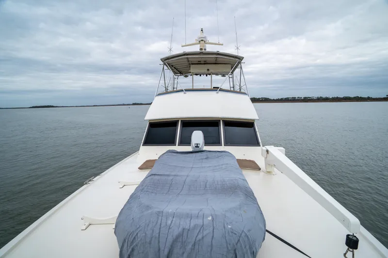 Slide: The Image of 1984 Hatteras 52 Convertible yacht on calm waters under cloudy sky. - 18