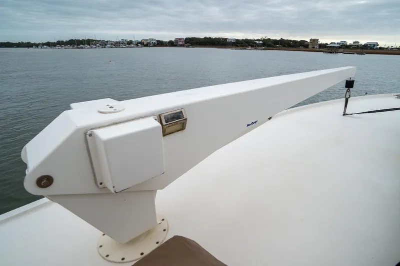 Slide: The Image of 1984 Hatteras 52 Convertible yacht deck with davit, overlooking calm waters. - 20