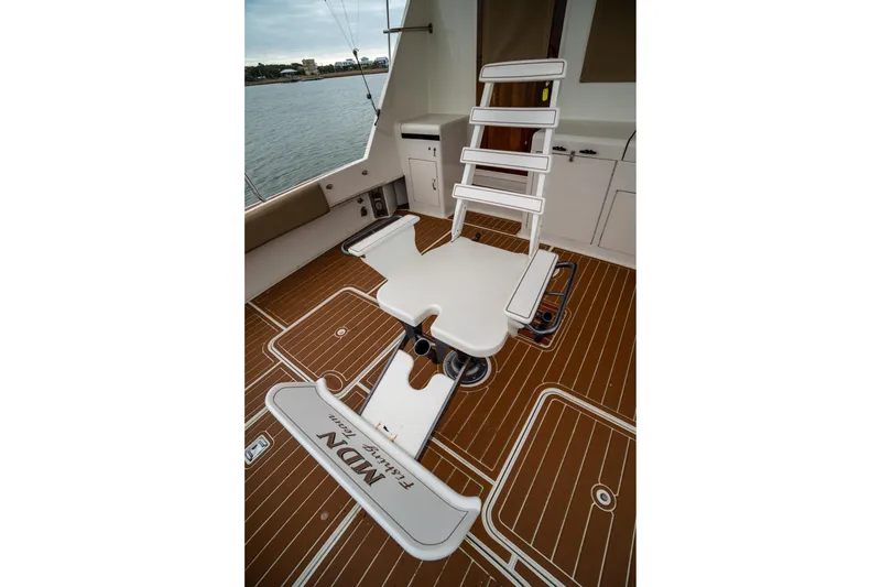 Slide: The Image of Fishing chair on 1984 Hatteras 52 Convertible yacht deck, overlooking water. - 32