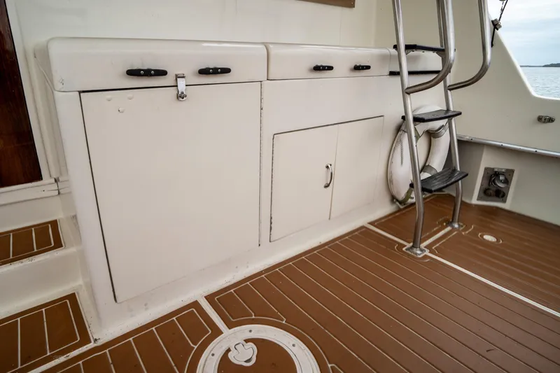 Slide: The Image of 1984 Hatteras 52 Convertible yacht deck with storage cabinets and ladder. - 35