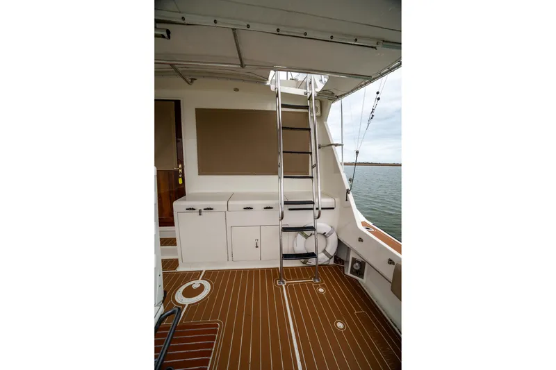 Slide: The Image of 1984 Hatteras 52 Convertible yacht deck with ladder and storage cabinets. - 38