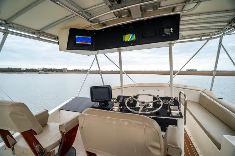 Slide: The Image of Helm of 1984 Hatteras 52 Convertible yacht with navigation equipment and panoramic water view. - 42