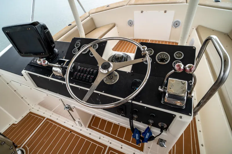 Slide: The Image of 1984 Hatteras 52 Convertible boat helm with steering wheel and control panel. - 44