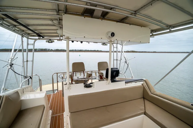 Slide: The Image of 1984 Hatteras 52 Convertible yacht interior with seating and navigation equipment on calm water. - 55