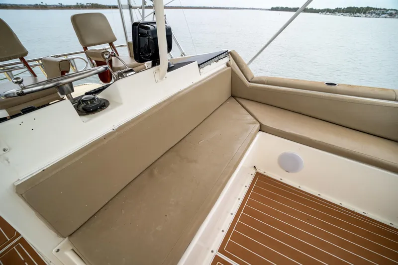 Slide: The Image of 1984 Hatteras 52 Convertible boat interior with beige seating and wooden deck. - 56