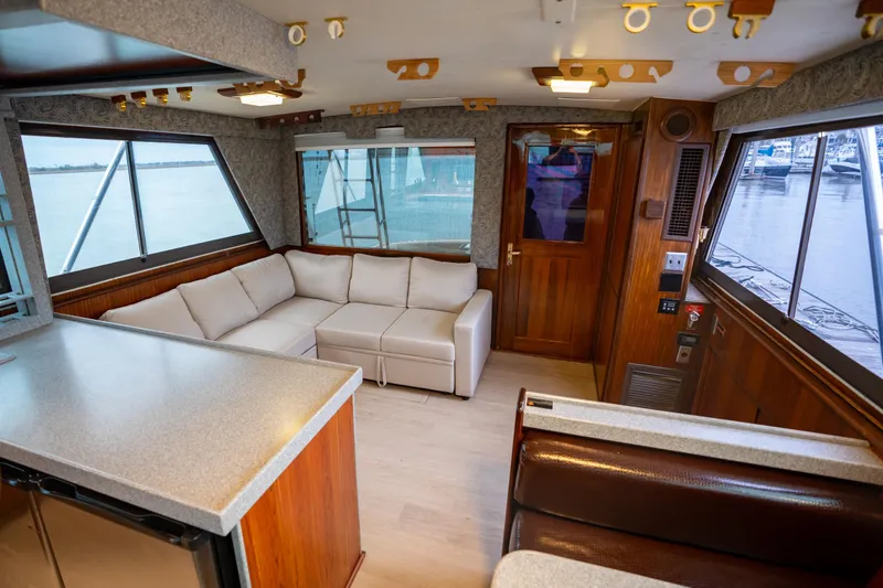 Slide: The Image of Interior of 1984 Hatteras 52 Convertible yacht with cozy seating and panoramic windows. - 63