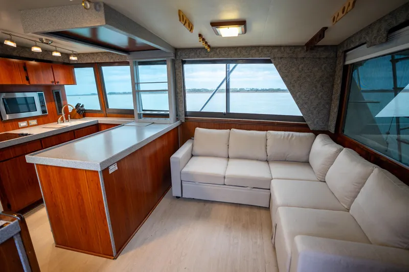 Slide: The Image of Luxurious interior of 1984 Hatteras 52 Convertible yacht with modern kitchen and cozy seating. - 64