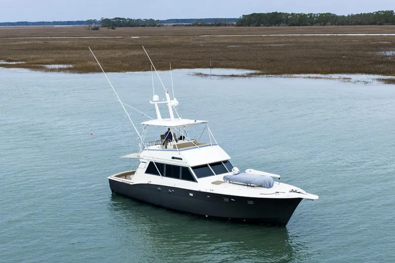 Slide: The Image of 1984 Hatteras 52 Convertible yacht on calm water, surrounded by marshland. - 7