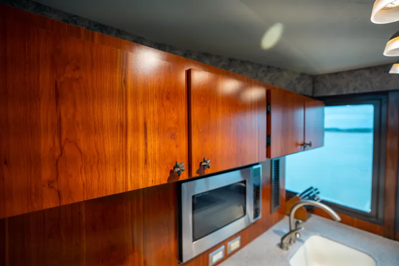 Slide: The Image of 1984 Hatteras 52 Convertible yacht kitchen with wooden cabinets and modern appliances. - 71