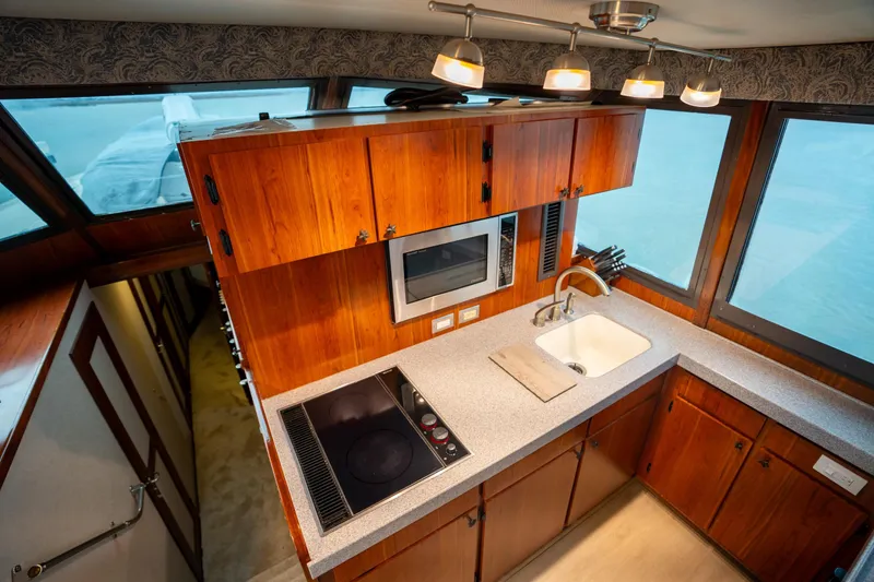Slide: The Image of 1984 Hatteras 52 Convertible yacht kitchen with wood cabinets, stove, and sink. - 72