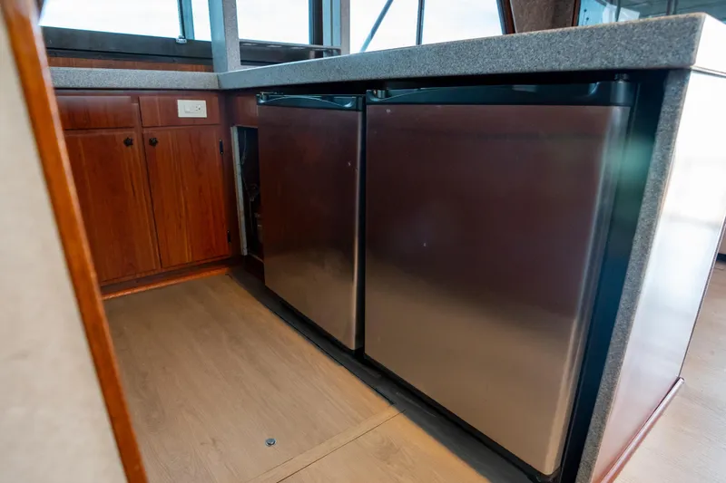 Slide: The Image of 1984 Hatteras 52 Convertible yacht interior with stainless steel appliances and wooden cabinetry. - 73