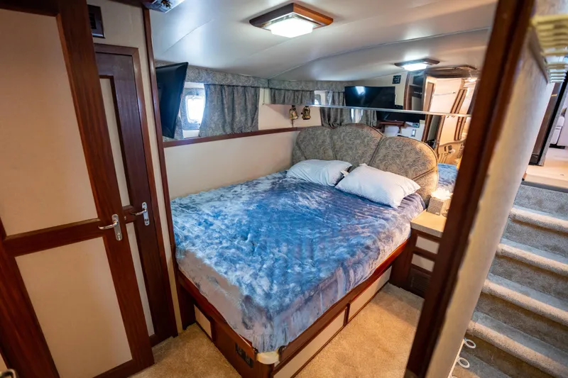 Slide: The Image of Luxurious bedroom interior of 1984 Hatteras 52 Convertible yacht with plush bedding. - 76