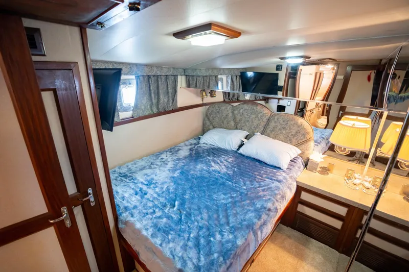 Slide: The Image of Luxurious bedroom interior of 1984 Hatteras 52 Convertible yacht with plush bedding and elegant decor. - 78
