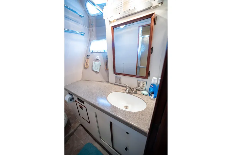 Slide: The Image of 1984 Hatteras 52 Convertible yacht bathroom with sink, mirror, and toiletries. - 81