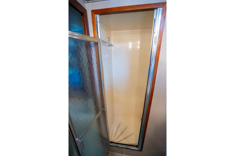 Slide: The Image of Shower area in 1984 Hatteras 52 Convertible yacht with glass door and wooden trim. - 83