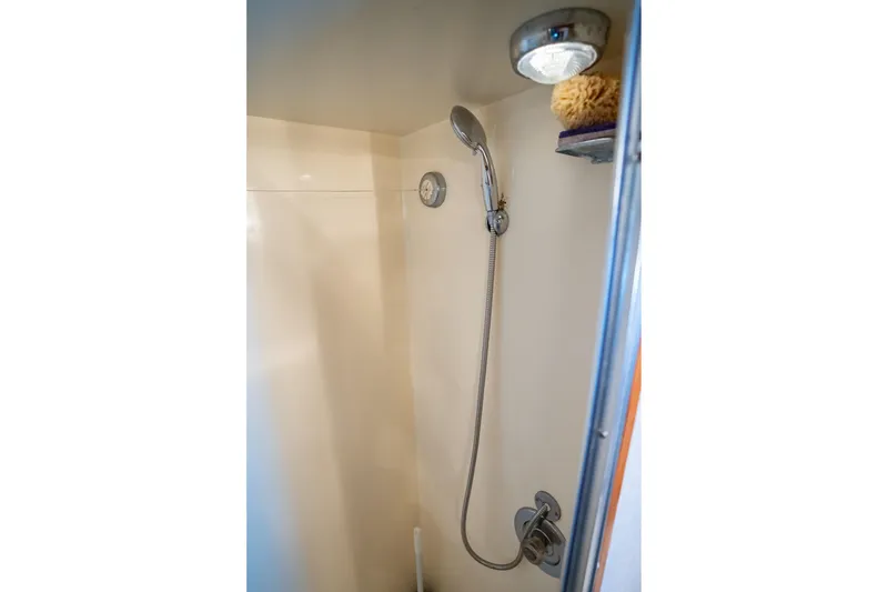 Slide: The Image of Shower area in 1984 Hatteras 52 Convertible yacht, featuring handheld showerhead and light. - 84