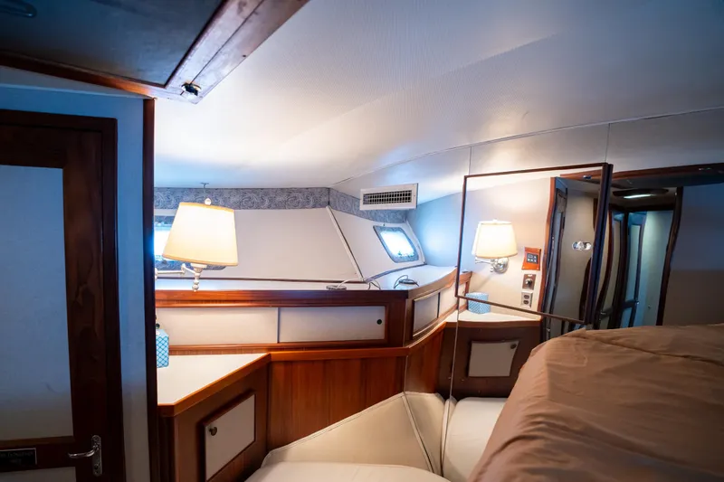Slide: The Image of Interior of 1984 Hatteras 52 Convertible yacht cabin with wood accents and cozy lighting. - 86