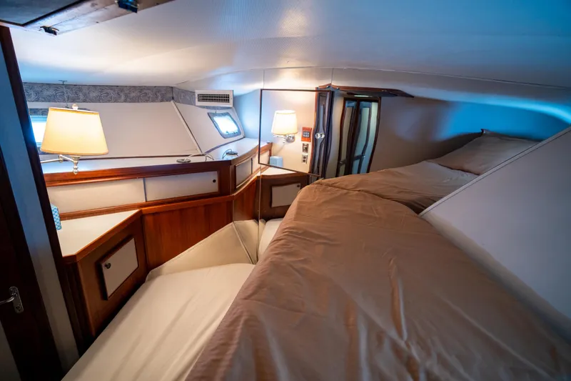 Slide: The Image of Interior cabin of 1984 Hatteras 52 Convertible yacht, featuring cozy beds and warm lighting. - 87