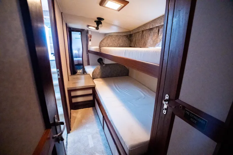 Slide: The Image of Interior of 1984 Hatteras 52 Convertible yacht with bunk beds and wooden furnishings. - 92