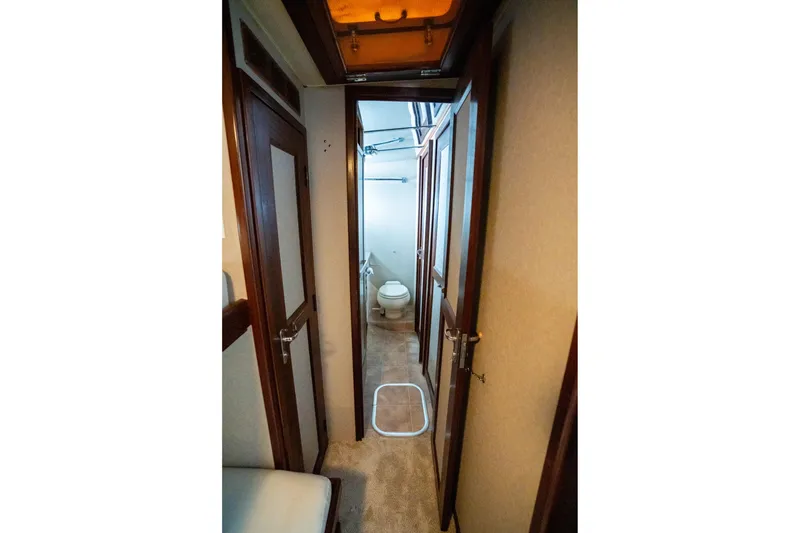 Slide: The Image of Interior hallway of 1984 Hatteras 52 Convertible yacht, featuring wooden doors and a bathroom. - 95
