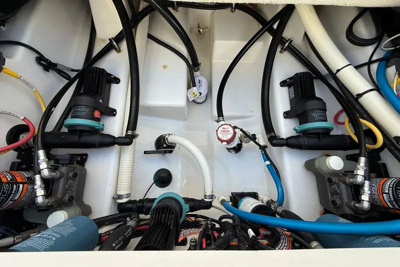 Slide: The Image of Engine compartment of a 2019 Blackfin 272 DC boat, showcasing pumps and hoses. - 20