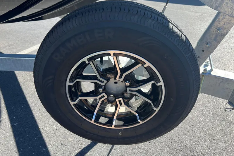 Slide: The Image of Trailer wheel of 2026 Crestliner 1870 Retriever FCC boat, featuring black alloy rim. - 4