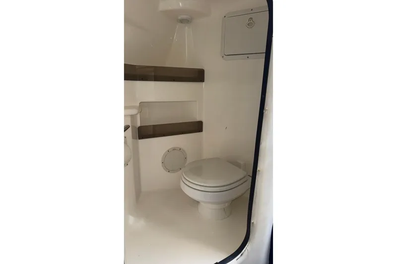 Slide: The Image of 2010 Fountain 42 Lightning boat interior bathroom with toilet and storage shelves. - 15