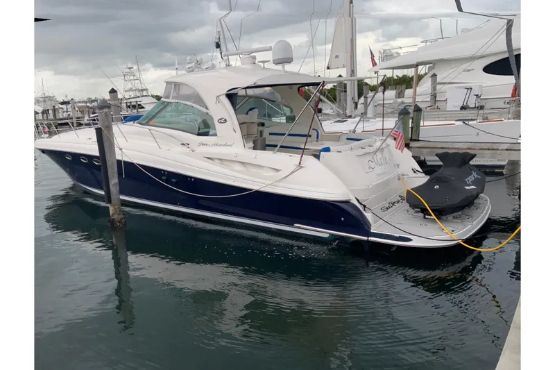 Slide: The Image of 2004 Sea Ray 500 Sundancer yacht docked at marina under cloudy skies. - 1