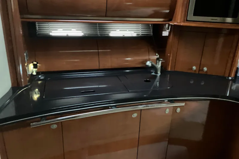 Slide: The Image of Luxurious kitchen area in a 2004 Sea Ray 500 Sundancer yacht with sleek cabinetry. - 12