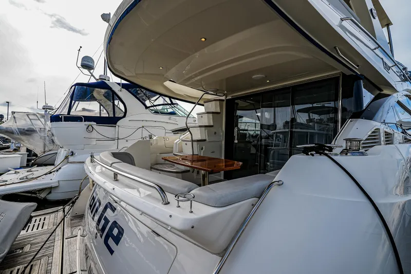 Slide: The Image of 2018 Sea Ray L590 Fly yacht docked, featuring spacious deck and luxurious seating area. - 10