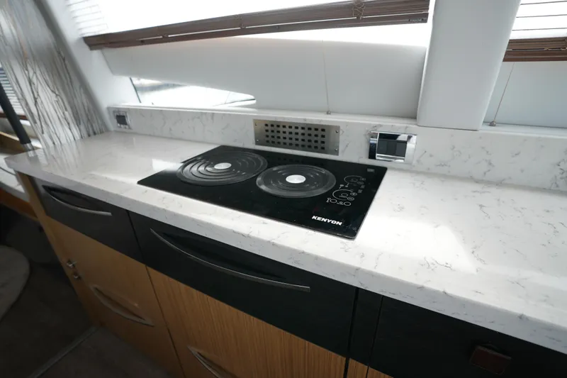 Slide: The Image of Modern kitchen in 2018 Sea Ray L590 Fly yacht with marble countertop and Kenyon cooktop. - 17