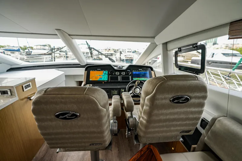 Slide: The Image of Luxurious 2018 Sea Ray L590 Fly yacht cockpit with dual helm seats and navigation screens. - 23