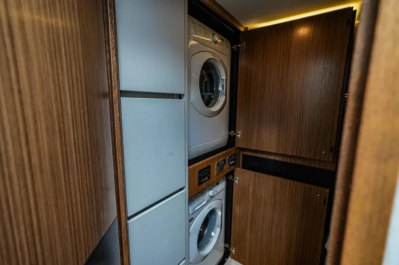 Slide: The Image of Laundry area with stacked washer and dryer in 2018 Sea Ray L590 Fly yacht. - 26