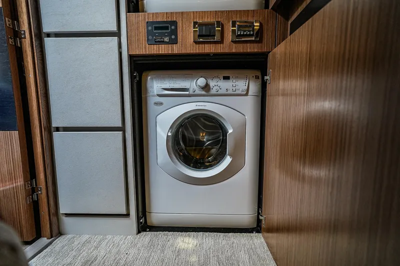 Slide: The Image of Washing machine in 2018 Sea Ray L590 Fly yacht interior, surrounded by wood paneling. - 27